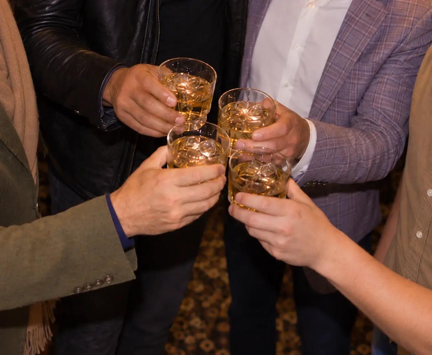 Four people raising glasses together at a previous event